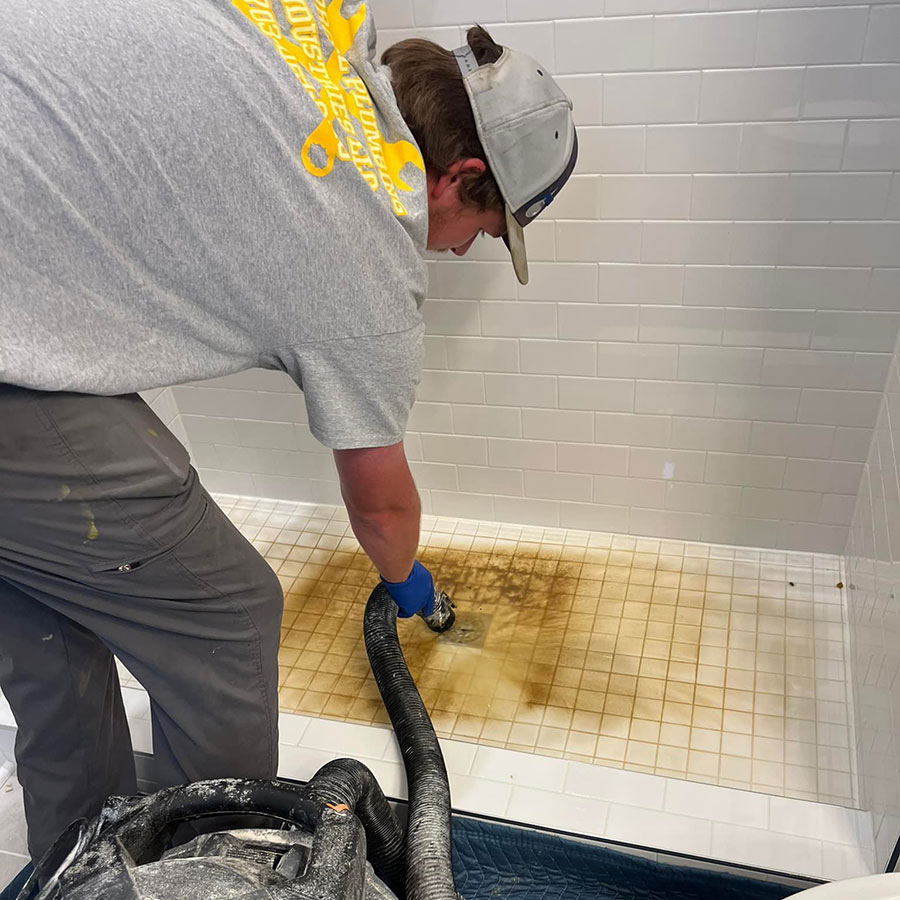 Emergency plumber clearing wastewater from a blocked residential shower drain in Warrenton, VA