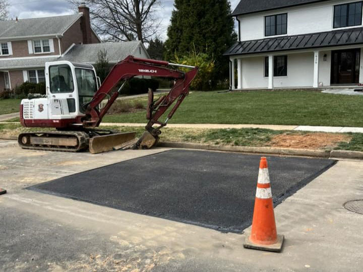 Residential sewer line repair completed with clean asphalt restoration